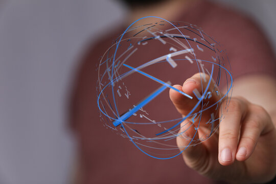 A person's hand touches a 3D globe made of lines. Concept of global network, future, and data visualization. - Powered by Adobe