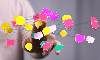 Hand touching network of speech bubbles representing communication, social media, internet, and information exc