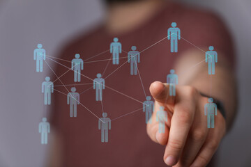 Hand pointing at a digital network of people. A visual representation of connection, communication, and social interaction within a futuristic c