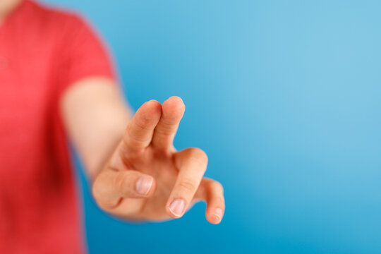 Human hand pointing toward screen on blue background. Contact concept, pressing, touch, finger. Perfect for digital interfaces, apps, websites,