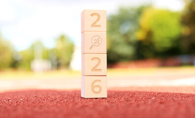 Wooden blocks display the year 2026, representing a cheerful message of hope and new beginnings as the festive spirit of Christmas fills the air in a bright outdoor setting