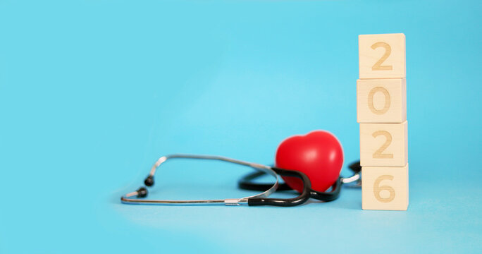 Celebrating New Year 2026 with a vibrant heart symbol and a stethoscope on a blue background. This setup highlights health and happiness during Christmas festivities