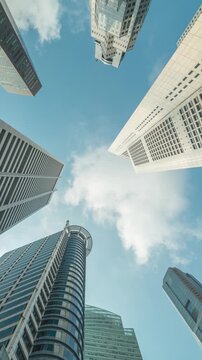 Singapore time lapse city skyline looking up under skyscraper building business district (vertical)