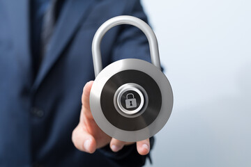 A businessperson holds a padlock, representing data protection, privacy, secure transactions, and cybersecurity