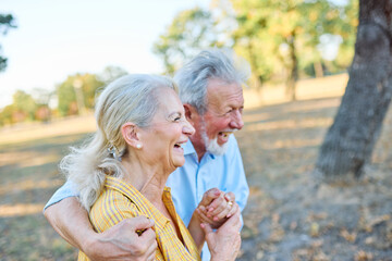 Fototapeta premium woman man senior couple happy retirement together elderly active vitality park fun smiling love old nature wife happiness mature walking holding hands