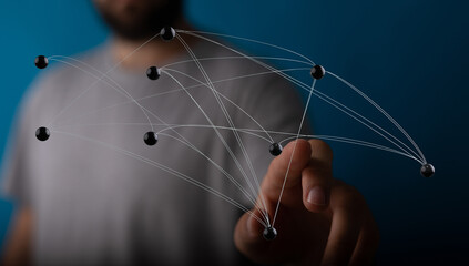 Close-up of hand interacting with a network diagram with nodes and connecting lines, representing concepts of i