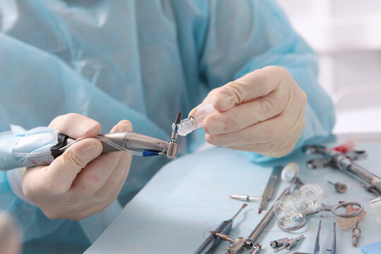 Dental implant placement. Dental implant in the hands of a surgeon. Modern dentistry. Concept of healthcare.