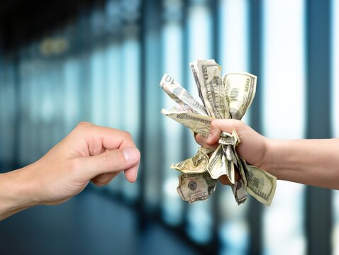 Hands hold money in office for corruption concept