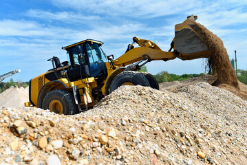 heavy construction machine in open-cast mining - wheel loader transports gravel in a gravel plant
