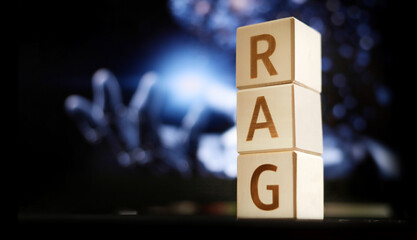 Blocks display the letters RAG while a blurred digital scene suggests advanced technology in the background. The focus is on the stacked letters against a high-tech backdrop