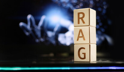 Blocks displaying the letters R, A, and G stand upright on a sleek surface. The backdrop features a blurred image of a robotic hand, highlighting advanced technology themes