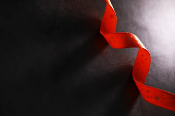 Red Star-Patterned Ribbon on Dark Background with Dramatic Shadow