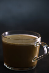 Close-Up of a Transparent Glass Mug Filled with Rich Dark Coffee on a Subtle Dark Background