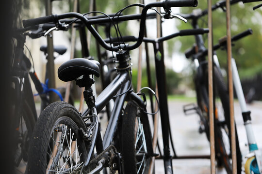 Close-Up of Black Bicycle Parked in Outdoor Rack on a Cloudy Day