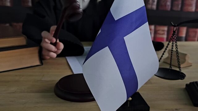 Courtroom session in Finland with judge and national flag displayed prominently