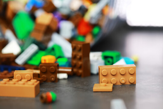 Colorful Plastic Building Blocks Scattered on Dark Surface in Creative Playroom Setting