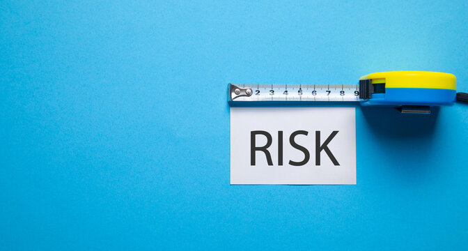 Tape measure with a word Risk on the blue background.