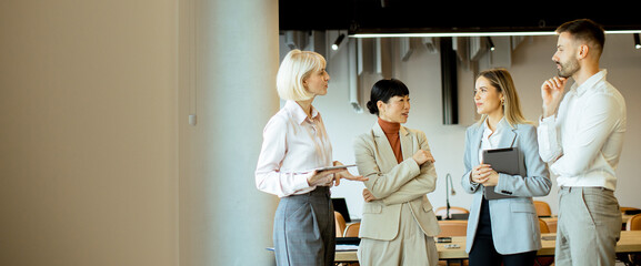 Business professionals engage in discussion during a meeting in a modern office space