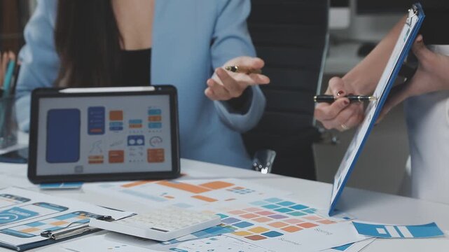 Two UX UI designers brainstorming mobile app wireframes in a modern startup office, showcasing creative teamwork, digital design