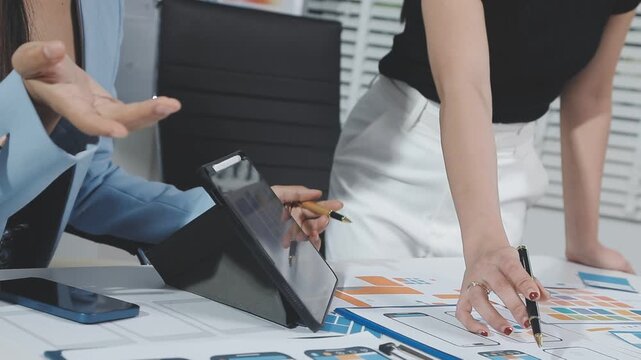Two UX UI designers brainstorming mobile app wireframes in a modern startup office, showcasing creative teamwork, digital design