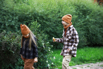 Siblings Enjoying Autumn Walk in Nature Wearing Cozy Apparel and Beanies