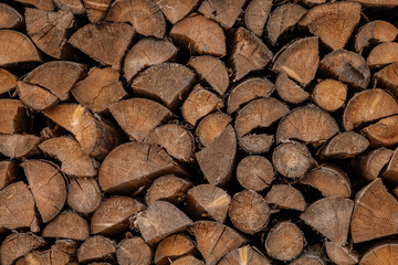 Wooden natural sawn logs as background, top view, flat lay. Wood texture. Firewood stack. 