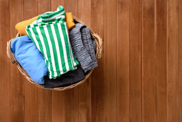 Clothes in a laundry wooden basket on wood table