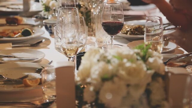 Closeup of group of people toasting with wine glasses at festive dinner table celebrating Thanksgiving together, copy space