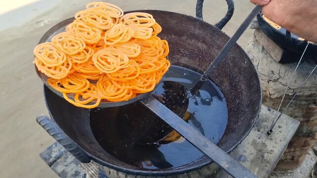 Jalebi is a Pakistani dessert. Sweet with sugar syrup fried in oil or ghee. Fresh batch of Jalebi. Crispy Jalebi.(traditional Pakistani sweet dessert). Pakistani jalebis arranged for sale. 4K Footage.