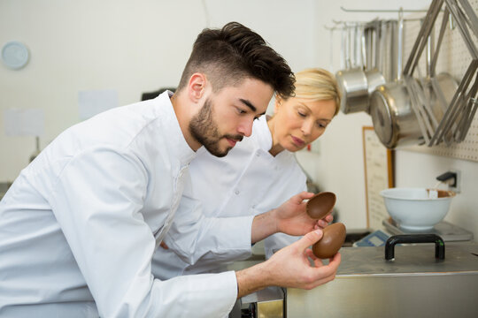 cheerful young man professional pastry cook at work