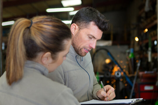 engineer communicating over clipboard with worker