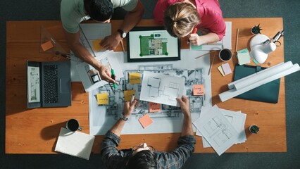 Top down view of civil engineer handed document while looking at blueprint. Aerial view of...