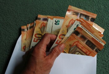 Dinero en billetes de cincuenta euros en efectivo en sobre blanco