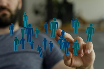 Close-up of hand touching digital human icons. Represents business networking, social media, and teamwork.