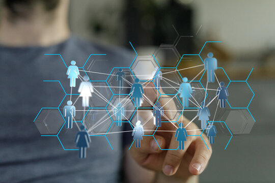 Close-up of a man's hand interacting with a holographic representation of a network of people. Modern, innovati