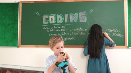 Asian boy coding program while caucasian friend fixing electric board at STEM class. Energetic student standing blackboard while writing coding engineering prompt and programing AI software. Pedagogy. - Powered by Adobe