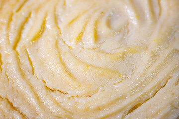 Detailed view of golden puff pastry rolls with a spiral pattern and glossy finish, placed on a white background. Lightly browned edges and soft, layered texture are visible.