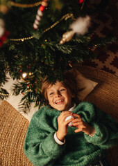 A boy decorates a Christmas tree