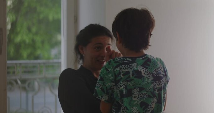 Mother and child sharing candid moment of genuine connection and warm conversation, expressing real affection and emotional closeness in calm home setting