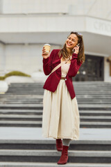 Fototapeta premium Business woman talking on the phone outdoors. Young woman talking on mobile phone walking in the street.