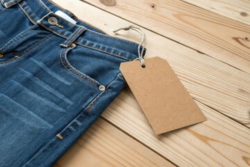 Buy denim jeans online stylish blue jeans with tag on wooden background