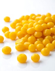 Fototapeta premium Close-up of a pile of small, vibrant yellow candies on a white surface