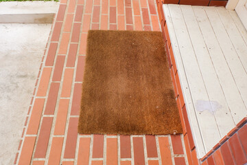 Welcome mat on red brick floor,Overhead of blank doormat at the front door,office or home,space for text.