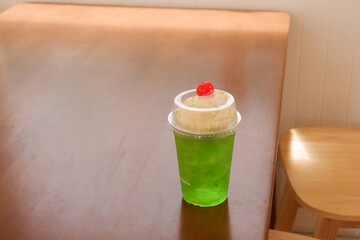 Melon soda float with vanilla ice cream and cherry on top in summer time,Melon soda is one of the most popular Japanese drink,Japanese cafe menu.
