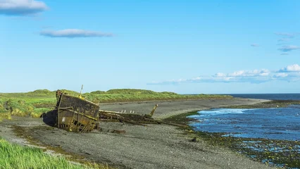Gordijnen Schip Front view of a rusty hull of an old ship abandoned on a beach.  © Luis G. Vergara
