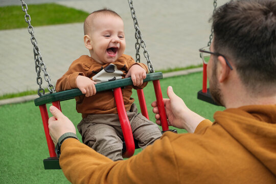 Father and Baby Enjoying Swing Time.