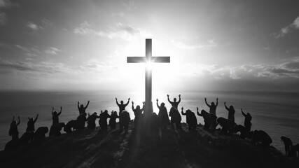 Silhouetted devout community adores holy cross, hands raised, bowing on mountain overlooking ocean. Brilliant sky above vast water inspires profound religious reverence.