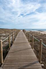 Obraz premium Boardwalk over dunes of Canide Beach on northern coast of Portugal in Vila Nova de Gaia under dramatic autumn cloudscape.