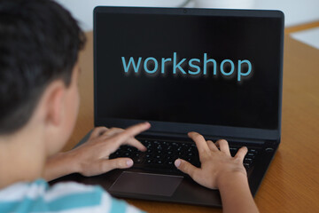 Technology and adolescence. WORKSHOP CONCEPT. Preteen child typing the word on his laptop.