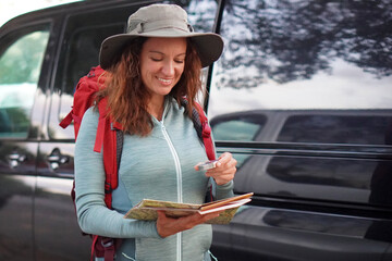 adventure and outdoor activities. Woman holding a map and compass, ready to start an orienteering activity.